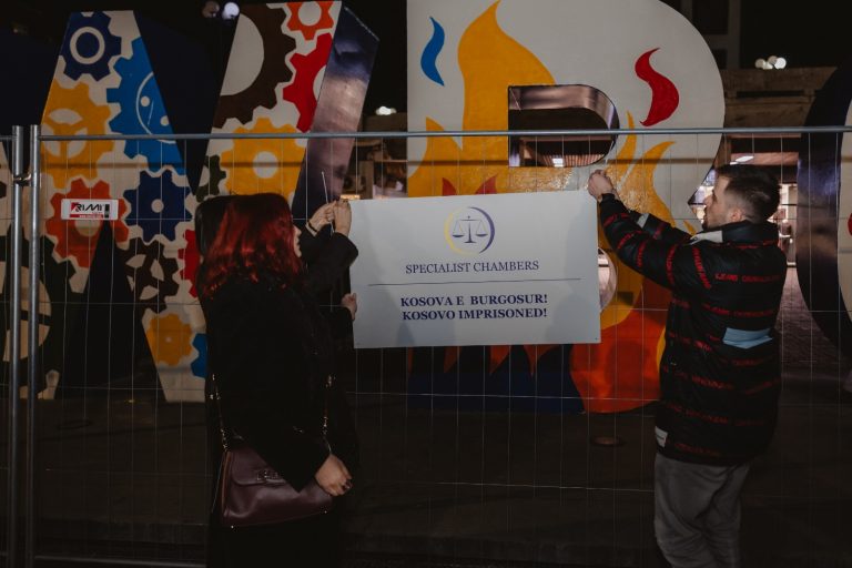 Në shënimin e 18-vjetorit të Pavarësisë së Kosova, monumenti NEWBORN shfaqet i “burgosur”, i rrethuar me simbole që kujtojnë qelitë dhe izolimin.